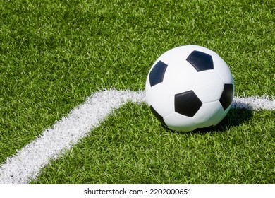 Soccer ball on green synthetic artificial grass soccer sports field with white corner stripe line - Powered by Shutterstock