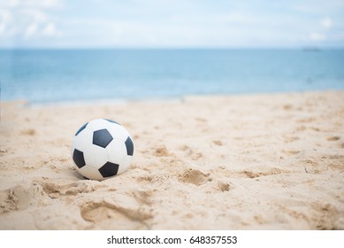 Soccer ball on sandy beach after game