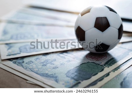 Soccer ball on stack of yen