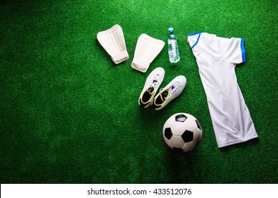 Soccer ball,cleats and various football stuff against artificial - Powered by Shutterstock