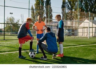 Soccer coach reviewing strategies with young boys soccer players - Powered by Shutterstock