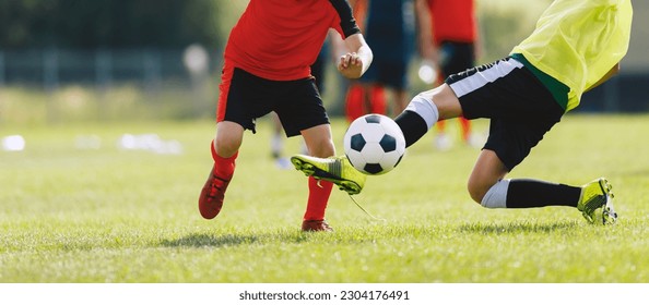 Soccer defensive player in action during a slide tackle. Two footballers in the competition game. Soccer duel between players attending training practice game - Powered by Shutterstock