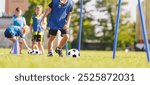 Soccer Drills: The Slalom Drill. Youth Football Practice Drills. Young Players in Training on the Pitch. Soccer Slalom Drill for Youth. Boy in Blue Training Soccer Jersey Shirt Running With Ball