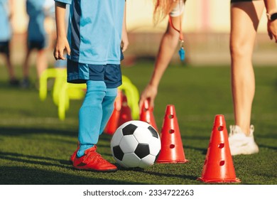 Soccer Drills: The Slalom Drill. Youth soccer practice drills. Physical education class with school coach trainer. Coach with whistle helping a child on training. Young football player on training - Powered by Shutterstock