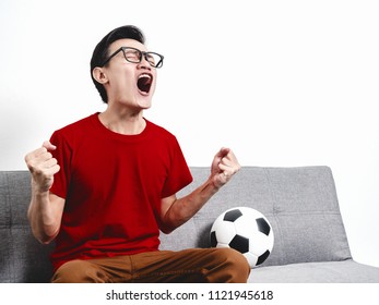 Soccer Fan Asian Thai People In Red Shirt Short Sleeve Victory Champion On Grey Sofa.