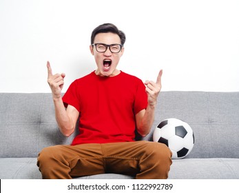 Soccer Fan Asian Thai People In Red Shirt Short Sleeve Victory Champion On Grey Sofa.