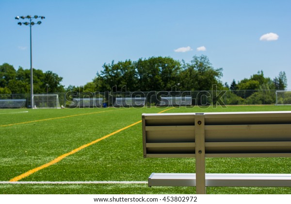 Soccer field with bench\
on a sunny day