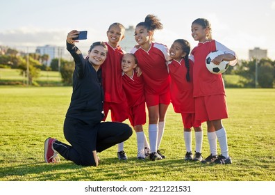 Soccer field, girl team and coach selfie for social media after training, competition and game together outdoors. Happy children, smile teacher and students community football academy taking photos - Powered by Shutterstock