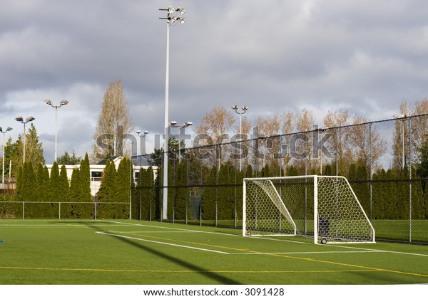 Soccer field with\
goal posts and light\
poles.
