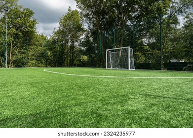 soccer field with white markings and green artificial grass cover, free and empty field - Powered by Shutterstock