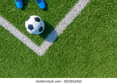 Soccer football background. Soccer ball and pair of football sports shoes on artificial turf soccer field with white line. Top view - Shutterstock ID 2025816362