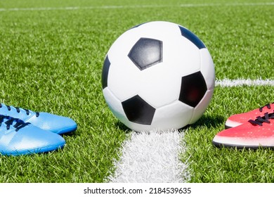 Soccer football background. Soccer ball and two pair of football sports shoes on artificial turf soccer field - Shutterstock ID 2184539635