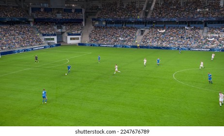 Soccer Football Championship Stadium with Crowd of Fans: Blue Team Forward Attacks, Dribbles, Players Defending The Goals, Ready To Counterattack. Sport Channel Broadcast Television. High Angle Wide.