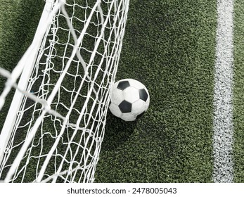 Soccer football in Goal net with green grass field. - Powered by Shutterstock