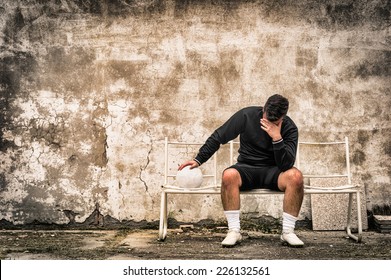 Soccer Football Goalkeeper Feeling Desperate Sitting On Bench After Sport Failure - Sad Concept Of Guilt And Defeat Related To Negative Doping Fail Experience - Dramatic Desaturated Filtered Look