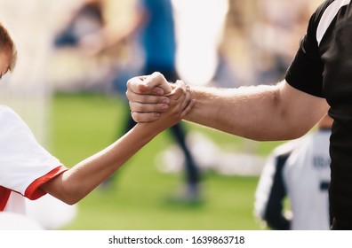 Soccer football kids player and junior team coach congratulating after the match. Greeting after soccer game. Trainer and child shaking hands after playing tournament match - Powered by Shutterstock
