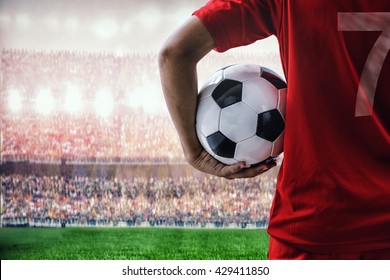 soccer football player in red team concept holding soccer ball in the stadium