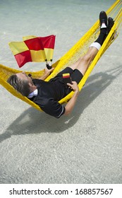 Soccer Football Referee Taking A Break From The World Cup To Relax At The Beach In Hammock With Coconut