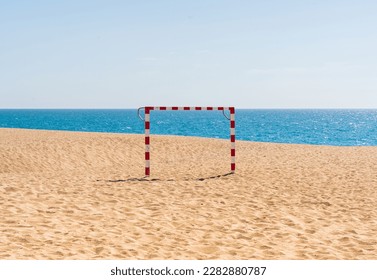 Soccer goal on a beach where you can see sky, sea and sand. Summer sports background