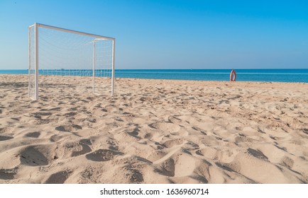 Soccer goal post on the beach with sand and blue sky