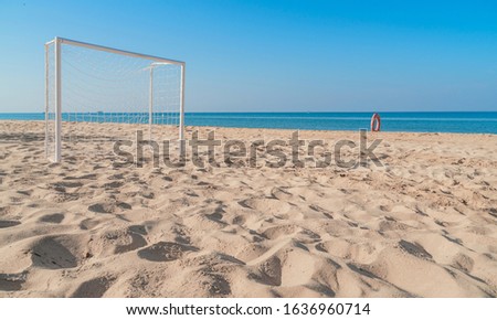 Soccer goal post on the beach with sand and blue sky