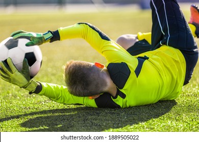 Soccer Goalie Catching Ball. Young Boy Goalkkeeper Saving Goal. Acrobatic Football Goalkeeper Save. Soccer Player in a Goal on a Sunny Summer Day. Soccer Goalie Training Unit