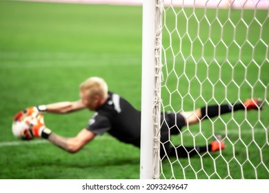 The soccer goalkeeper saves the goal from a penalty kick while jumping. Selective focus on the boom