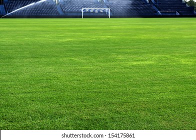 A Soccer Grass Field Is Watered In The Evening. 