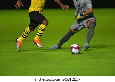 soccer motion blur on green foot ball field. The center forward throws the ball past the goalkeeper.