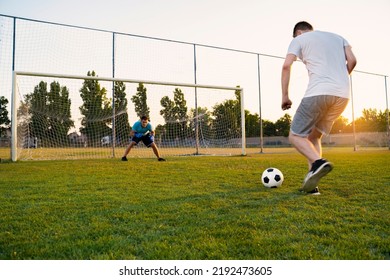 Soccer Penalty Shootout Concept, Two Men Playing Soccer At Sunset, Preparing To Kick The Ball 