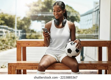 Soccer, phone and black woman football athlete with a ball on sports rest after exercise and fitness. Training workout and game break of a healthy person smile using mobile technology and 5g internet - Powered by Shutterstock