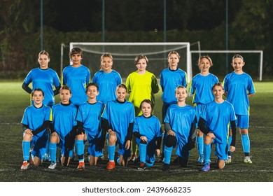 soccer player Caucasian little girls posing for a team photo in a stadium in the evening, blue uniforms. High quality photo - Powered by Shutterstock