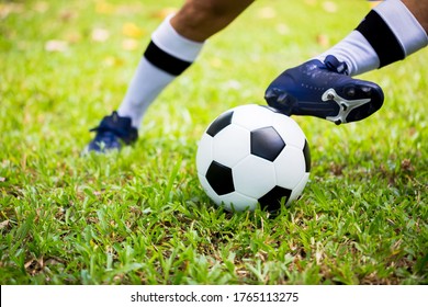 Soccer player control to shoot ball on green grass to goal. Soccer player training for match. Football player in football academy.