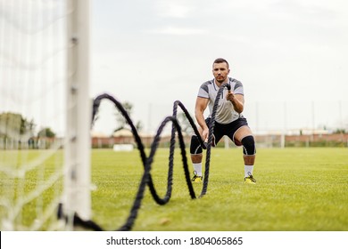 Soccer player doing exercises on the field. He is doing exercises with battle ropes. - Powered by Shutterstock