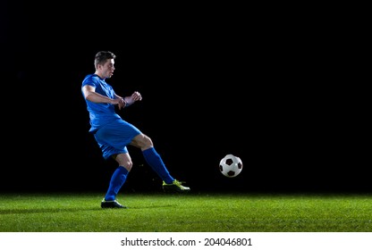soccer player doing kick with ball on football stadium  field  isolated on black background