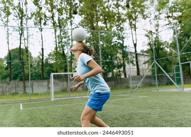 soccer player girl juggles the ball on her head. Football - Powered by Shutterstock