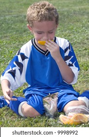 Soccer Player At Halftime Eating Orange With Drink Pouch