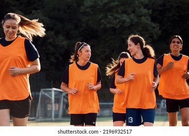 Soccer player and her teammate communicating while warming up and running on playing field.  - Powered by Shutterstock