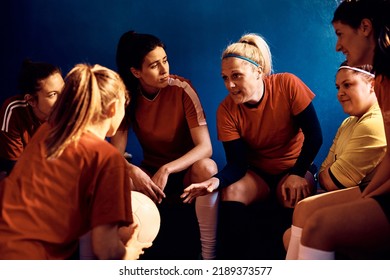 Soccer player and her teammates discussing tactics in dressing room. - Powered by Shutterstock