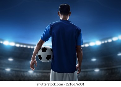 Soccer player holding ball in the stadium