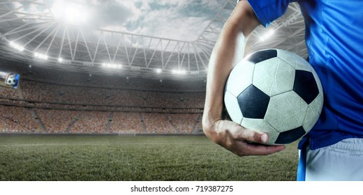 Soccer player holds a soccer ball on a professional stadium. Player wears unbranded clothes. - Powered by Shutterstock