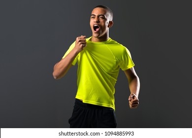 Soccer player man with dark skinned playing celebrating victory on dark background - Powered by Shutterstock