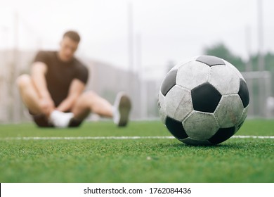 soccer player A man holds his foot. focus on the soccer ball. Dislocation or sprain of the joint. The concept of falling during sports. Break your leg in training - Powered by Shutterstock