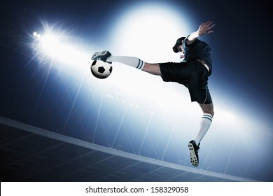 Soccer player in mid air kicking soccer ball - Powered by Shutterstock