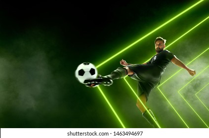 Soccer Player On Smoke Background. Green Neon Light.