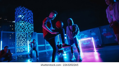 Soccer Player Performing Freestyle Tricks with a Ball. Footballer Showing Off Juggling Skills. Urban Spot with Neon Lights, Graffiti on Walls and Scenery with Skyscrapers at Night