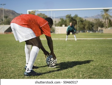 Soccer player preparing for penalty kick, back view