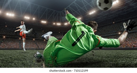 Soccer Player Scoring A Goal. Goalkeeper Tries To Hit The Ball. Players Wears Un-brand Uniform.