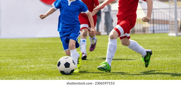 Soccer Players in a Duel. Elementary Age Kids in Soccer Clubs of Soccer Academies. Two Children Sports Team Kicking Football Match on Grass Pitch - Powered by Shutterstock