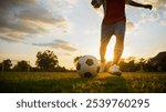 Soccer Players Kicking Ball with Sunset Background. Football Match Team Practice on Field.